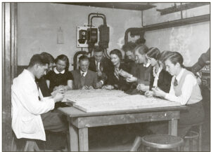Photo: Arie Jan Haagen-Smit (left), an organic chemist, works on oat seedlings alongside botanists in the basement of the Botanical Laboratory at Utrecht University. Copyright: Arie Jan Haagen-Smit Papers, Box 15, Folder 8, Caltech Archives, Pasadena.